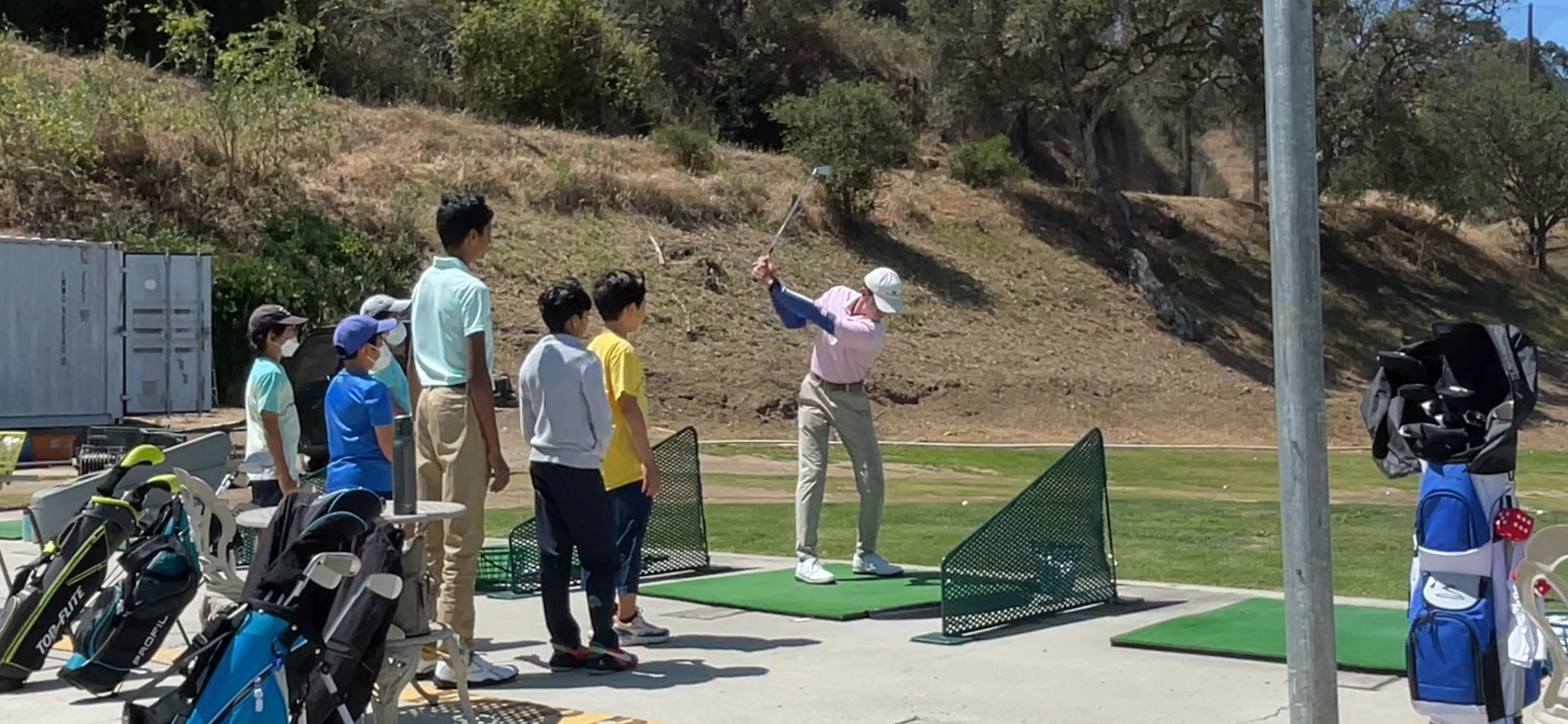 Golf Upgrades Golf Coach in San Diego, Jacob Williams, PGA Associate teaching young golfers by demonstrating a golf swing at Sorrento Canyon Golf Center located in San Diego, CA.